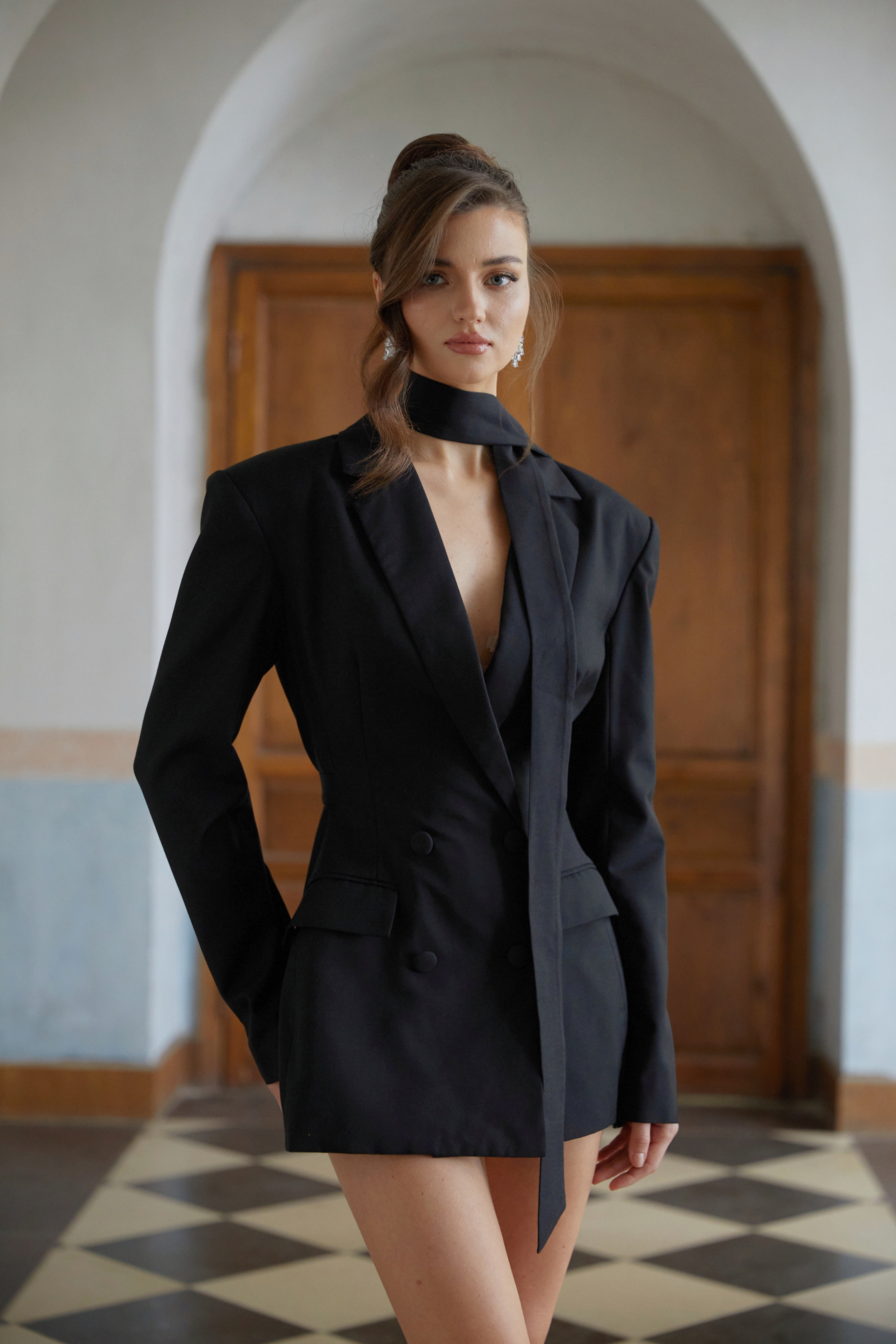 Black double-breasted blazer dress with structured shoulders and a matching neck tie