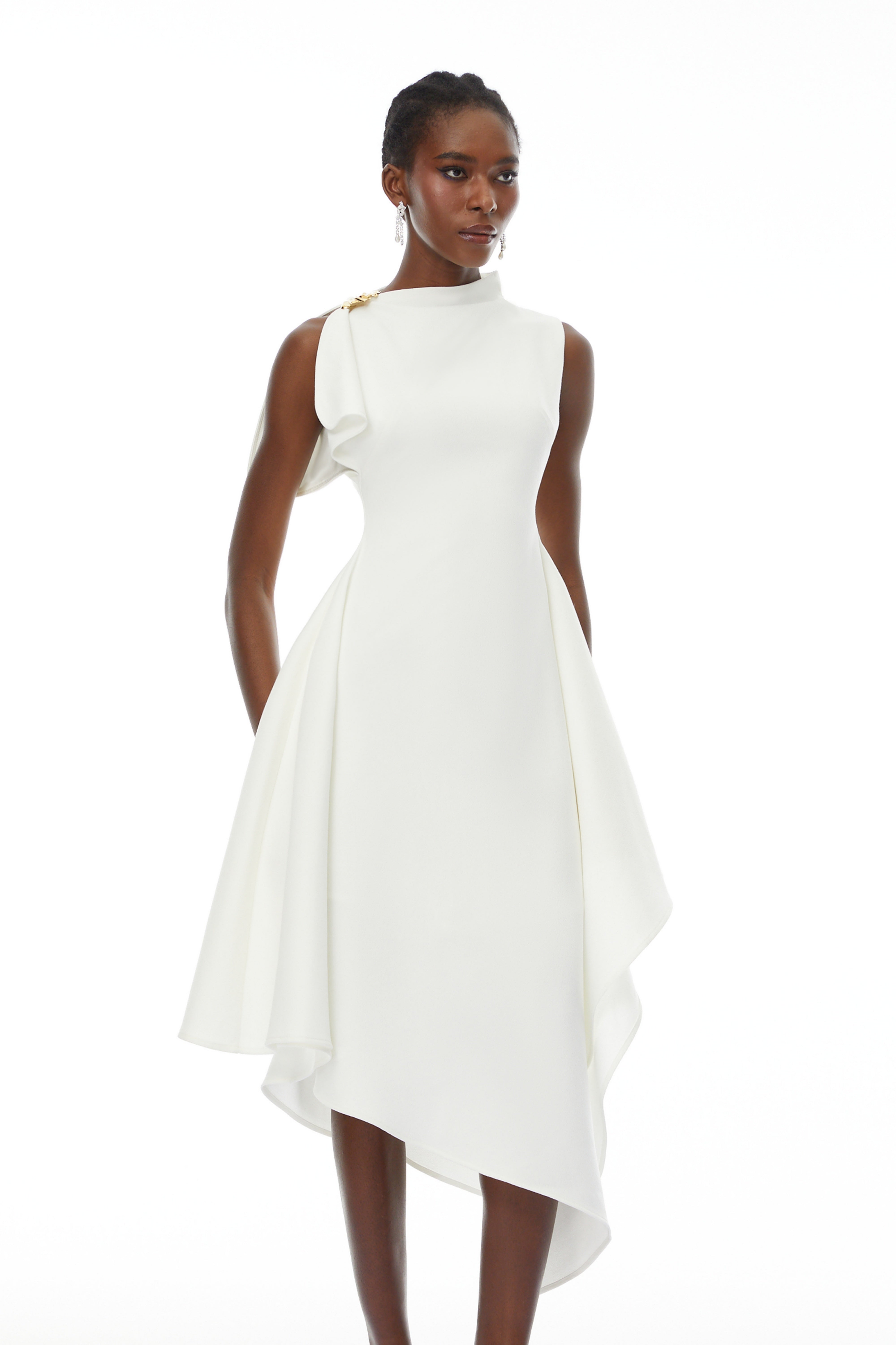 White sleeveless midi dress featuring a high drape neck with a brooch detail and a structured asymmetric handkerchief skirt