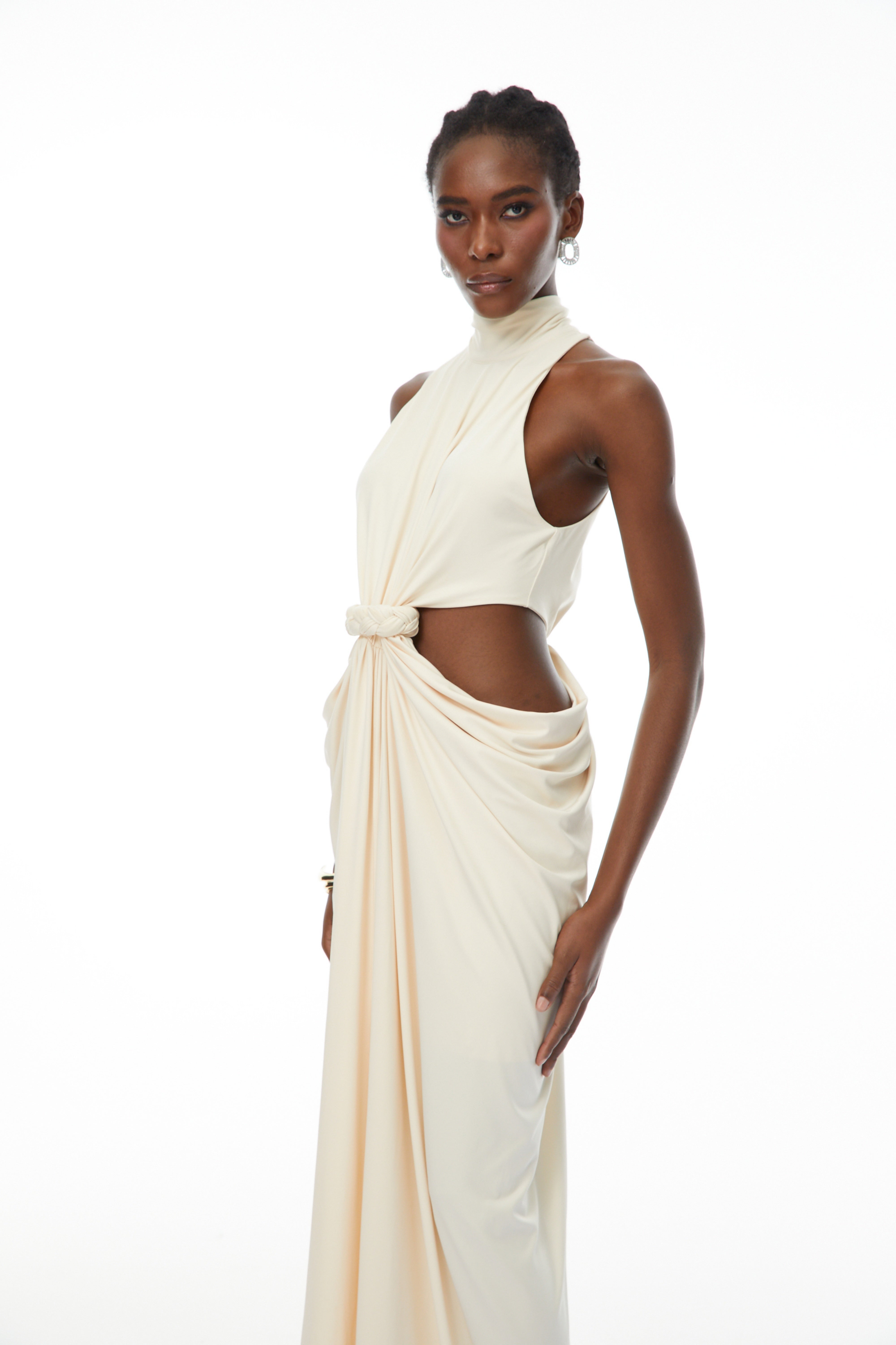 Robe longue couleur crème à dos nu, avec découpes à la taille et corsage drapé noué