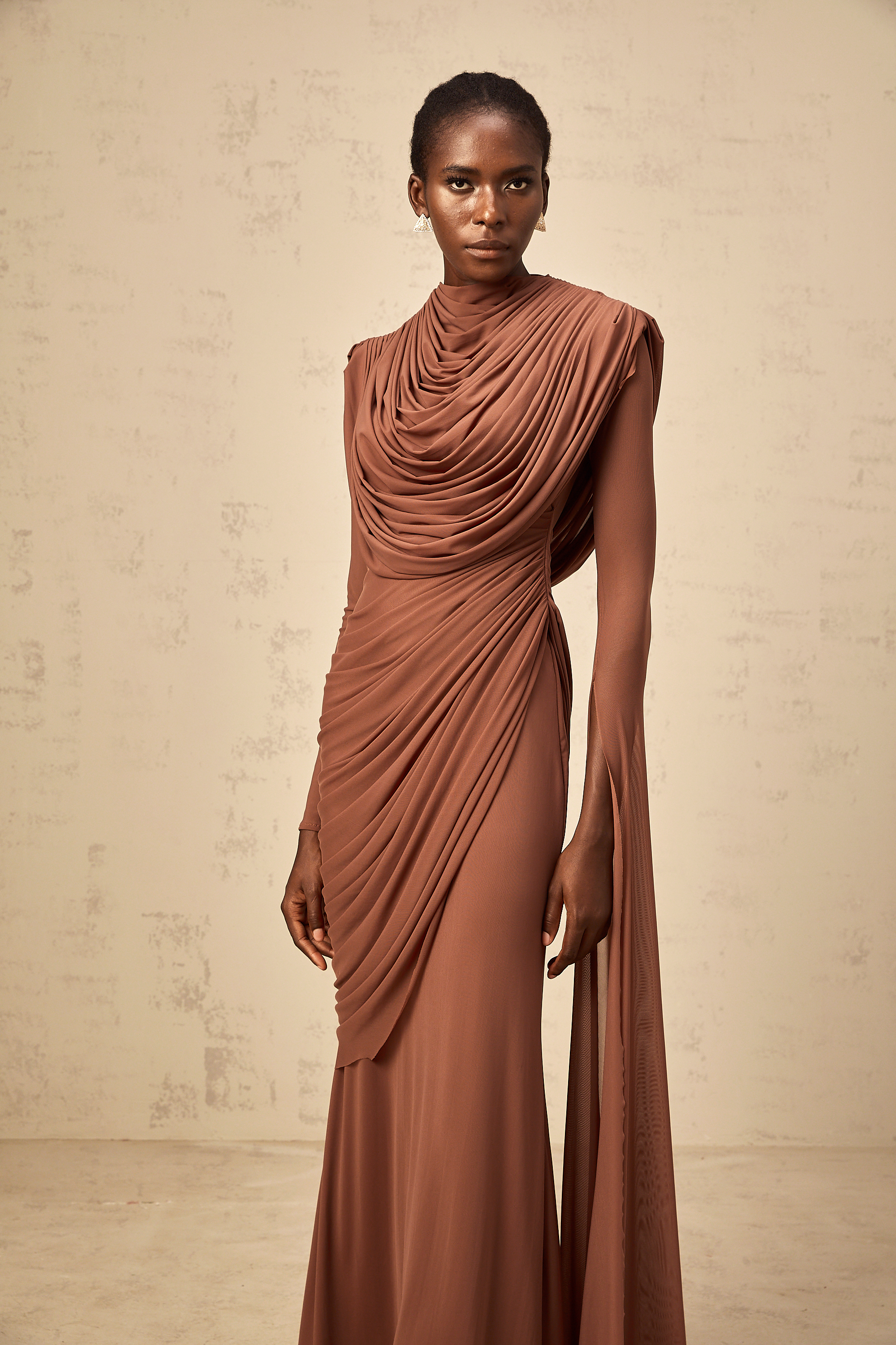Rust-colored long-sleeve maxi dress with a draped cowl neckline and pleated bodice