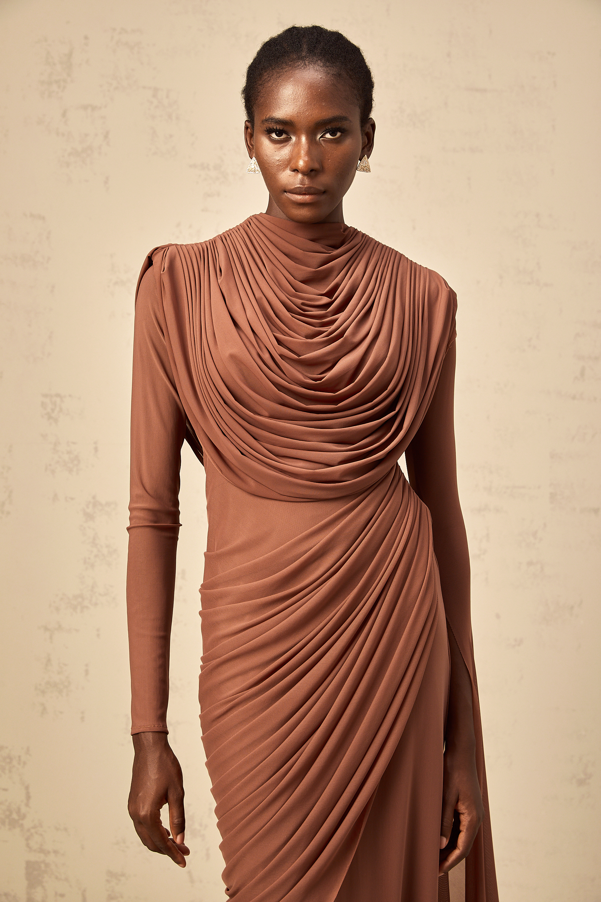 Rust-colored long-sleeve maxi dress with a draped cowl neckline and pleated bodice