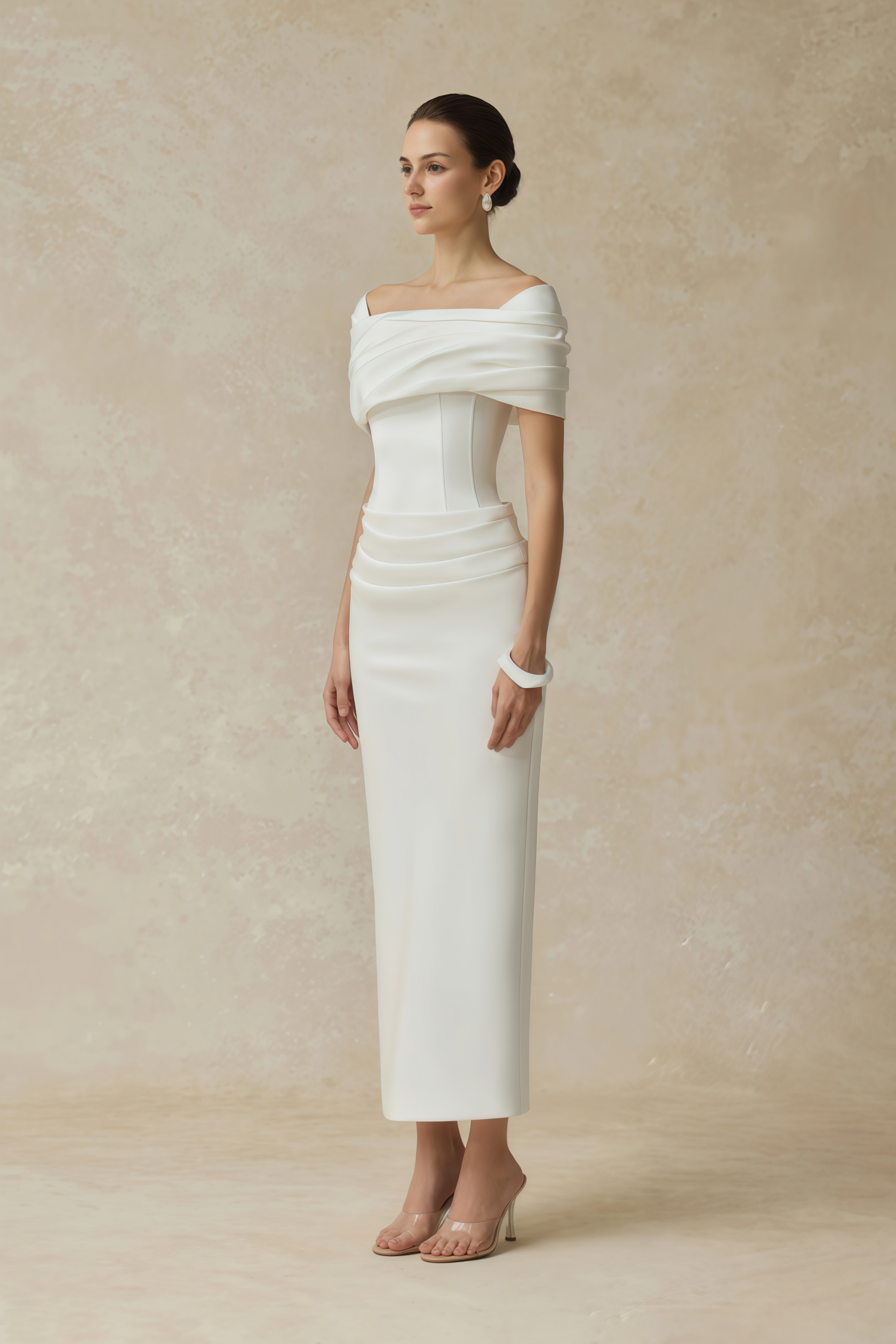 White off-the-shoulder gown with a draped bodice and cascading side ruffles