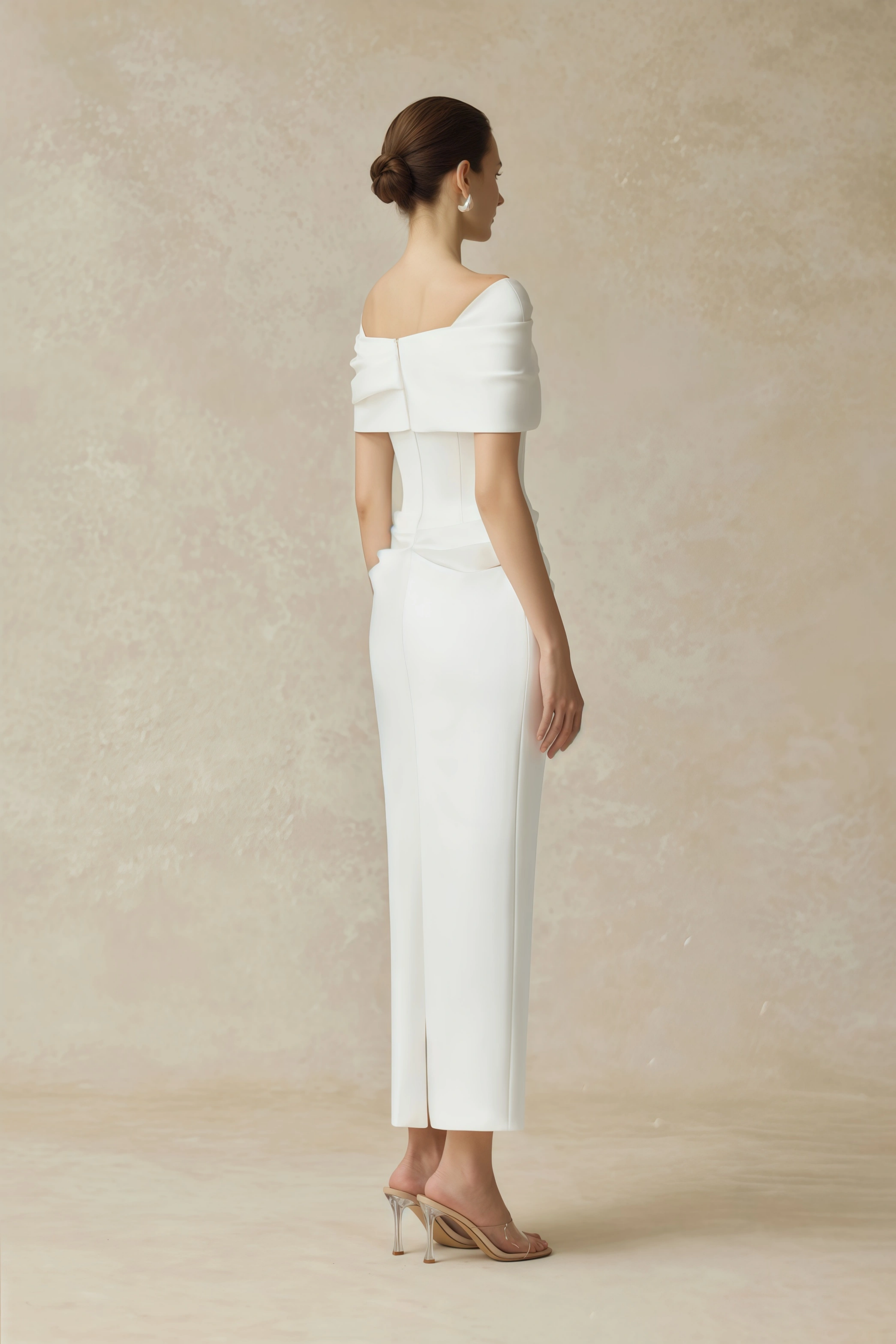 White off-the-shoulder gown with a draped bodice and cascading side ruffles