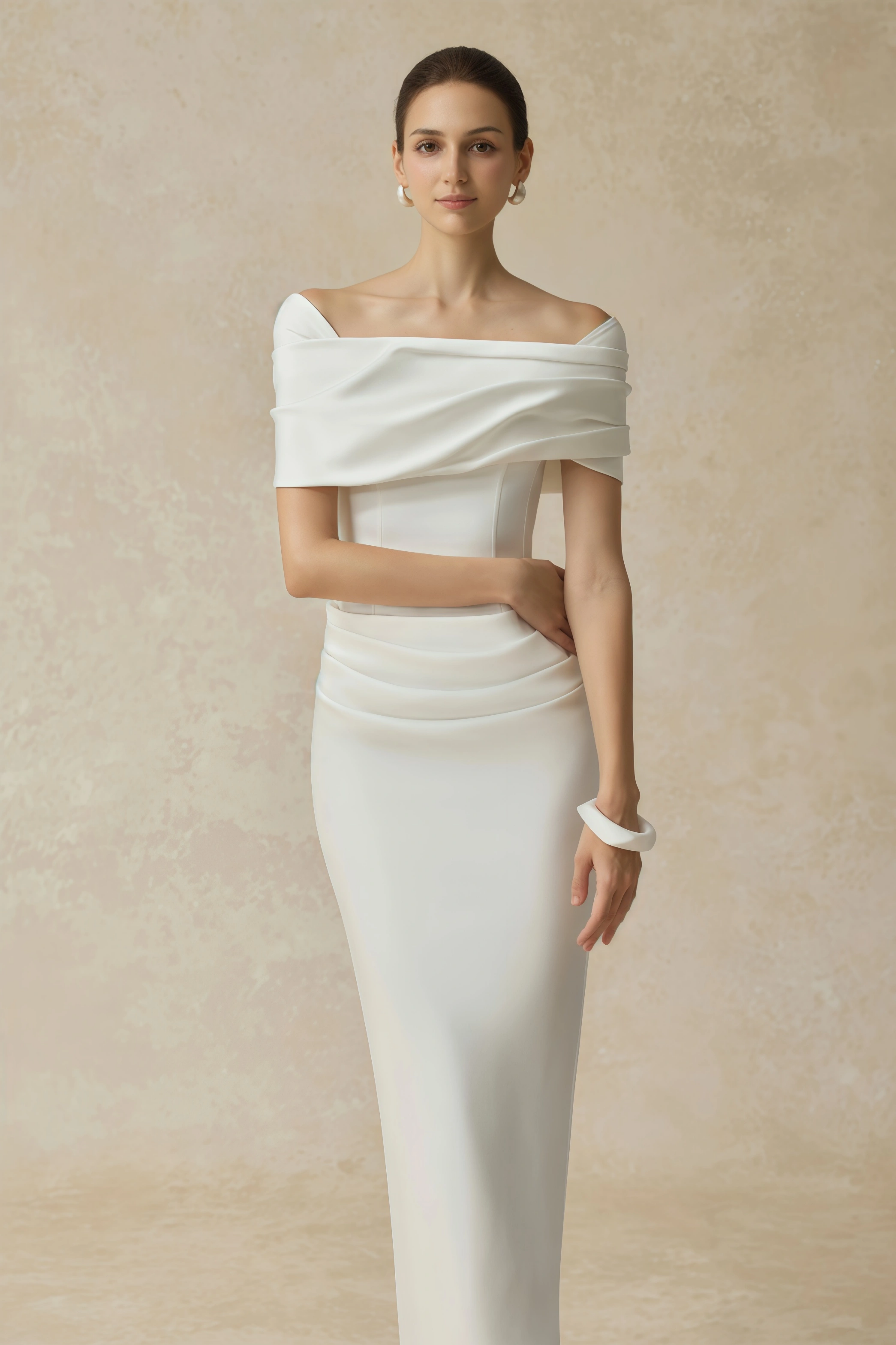 White off-the-shoulder gown with a draped bodice and cascading side ruffles