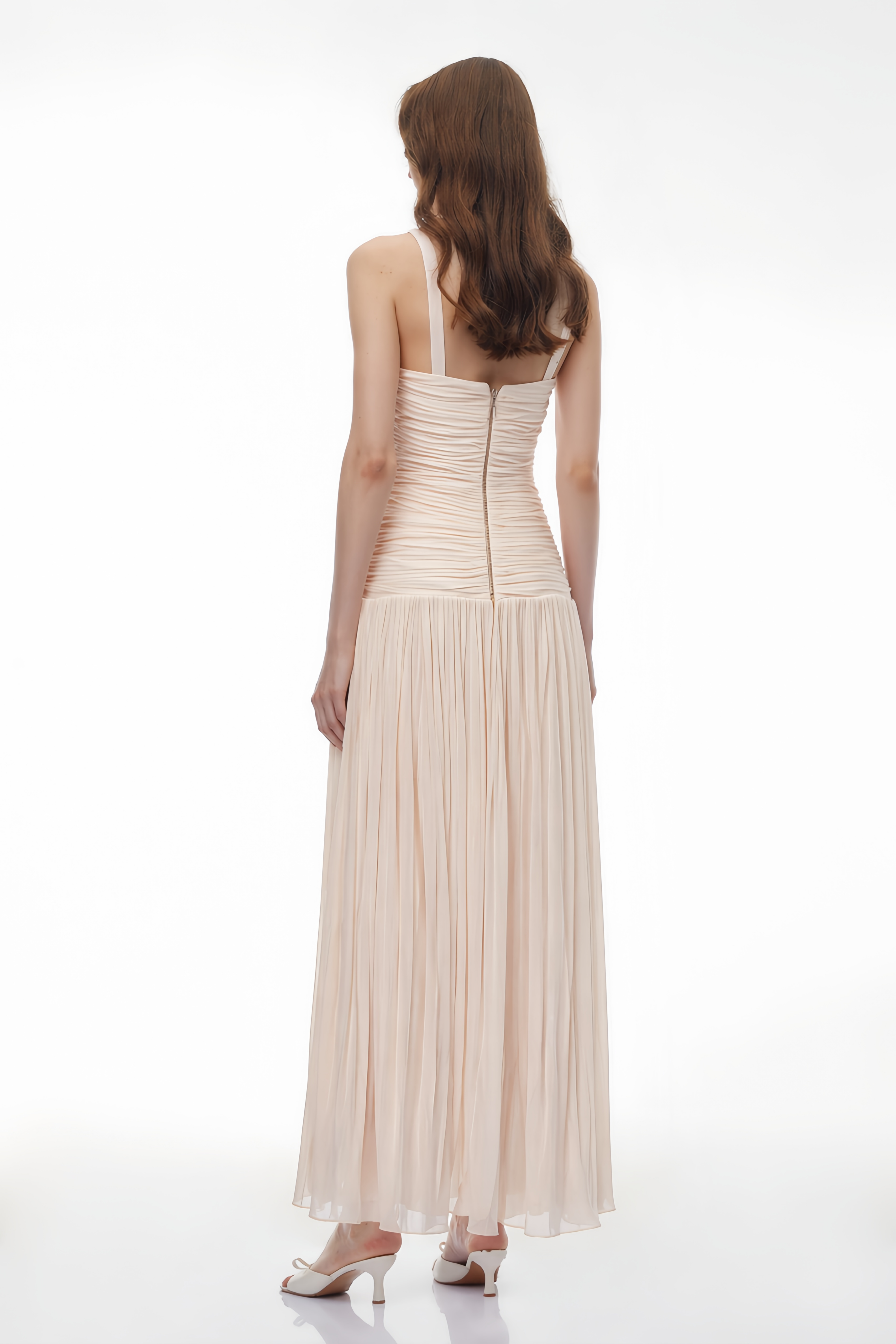 Robe longue rose pâle composée d'un corsage en dentelle blanche transparente, d'une ceinture drapée et torsadée, et d'une jupe finement plissée