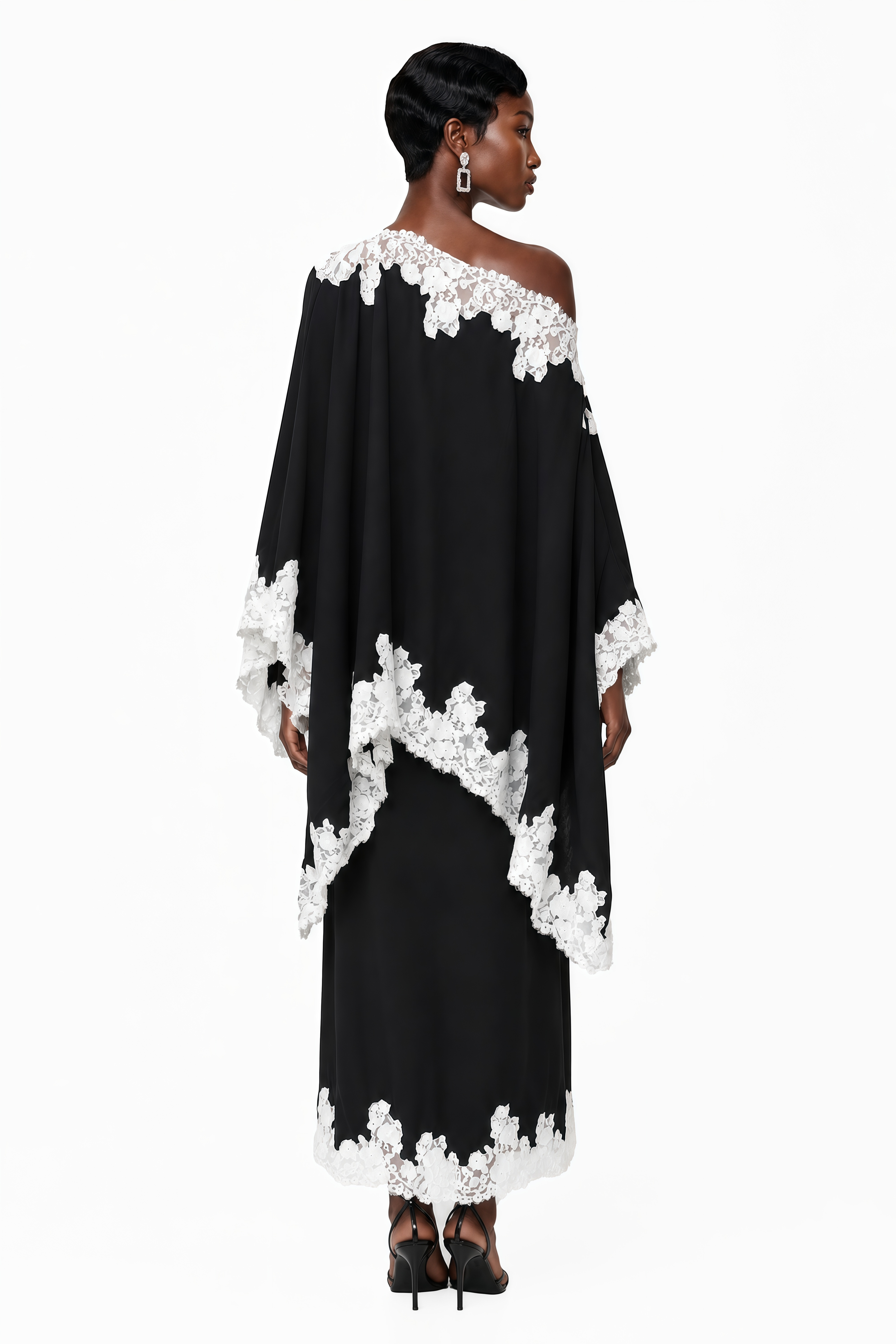 Black one-shoulder maxi dress with an asymmetric lace-trimmed cape and lace-trimmed hem