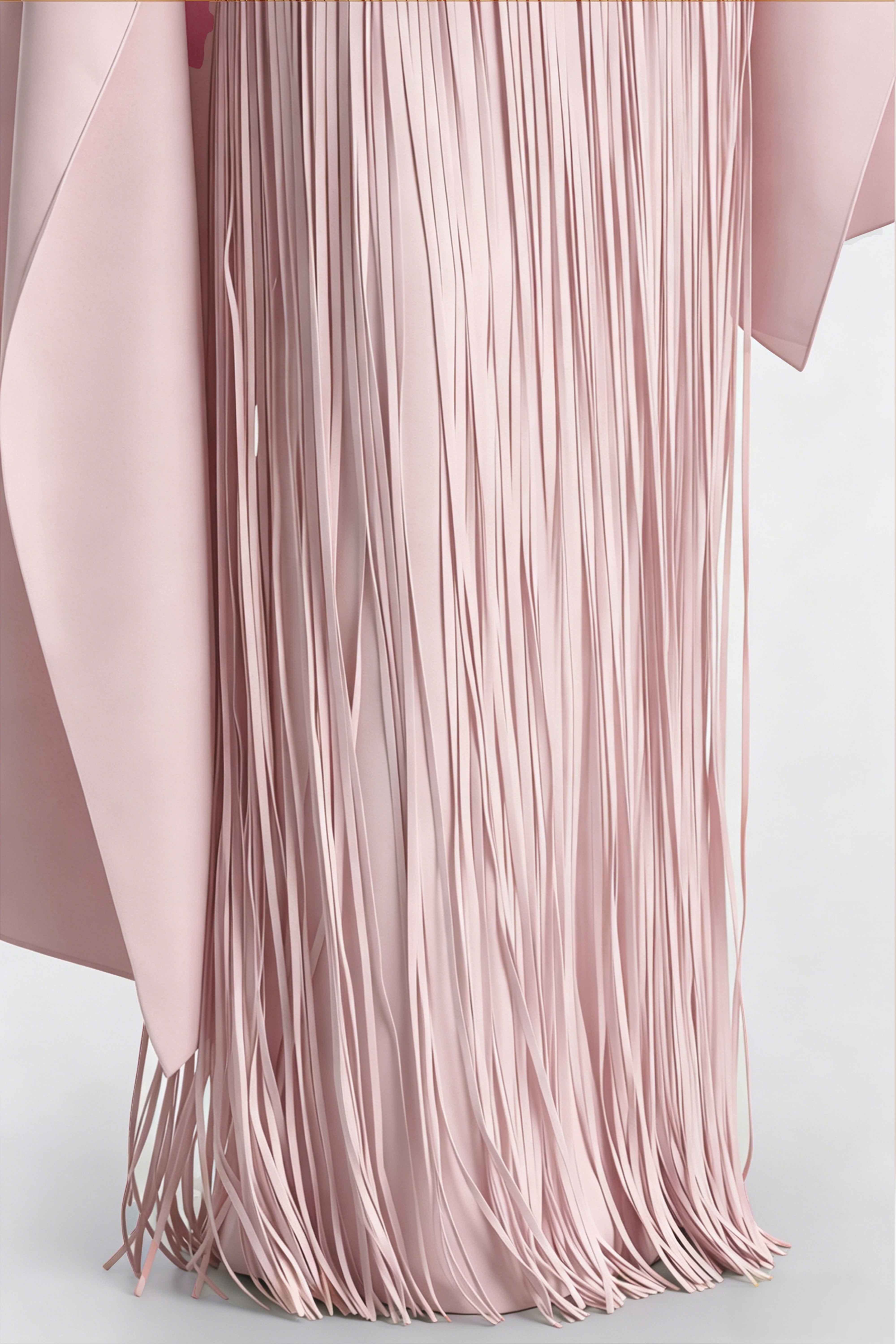 Light pink cape maxi dress with an asymmetrical waist and long fringe skirt
