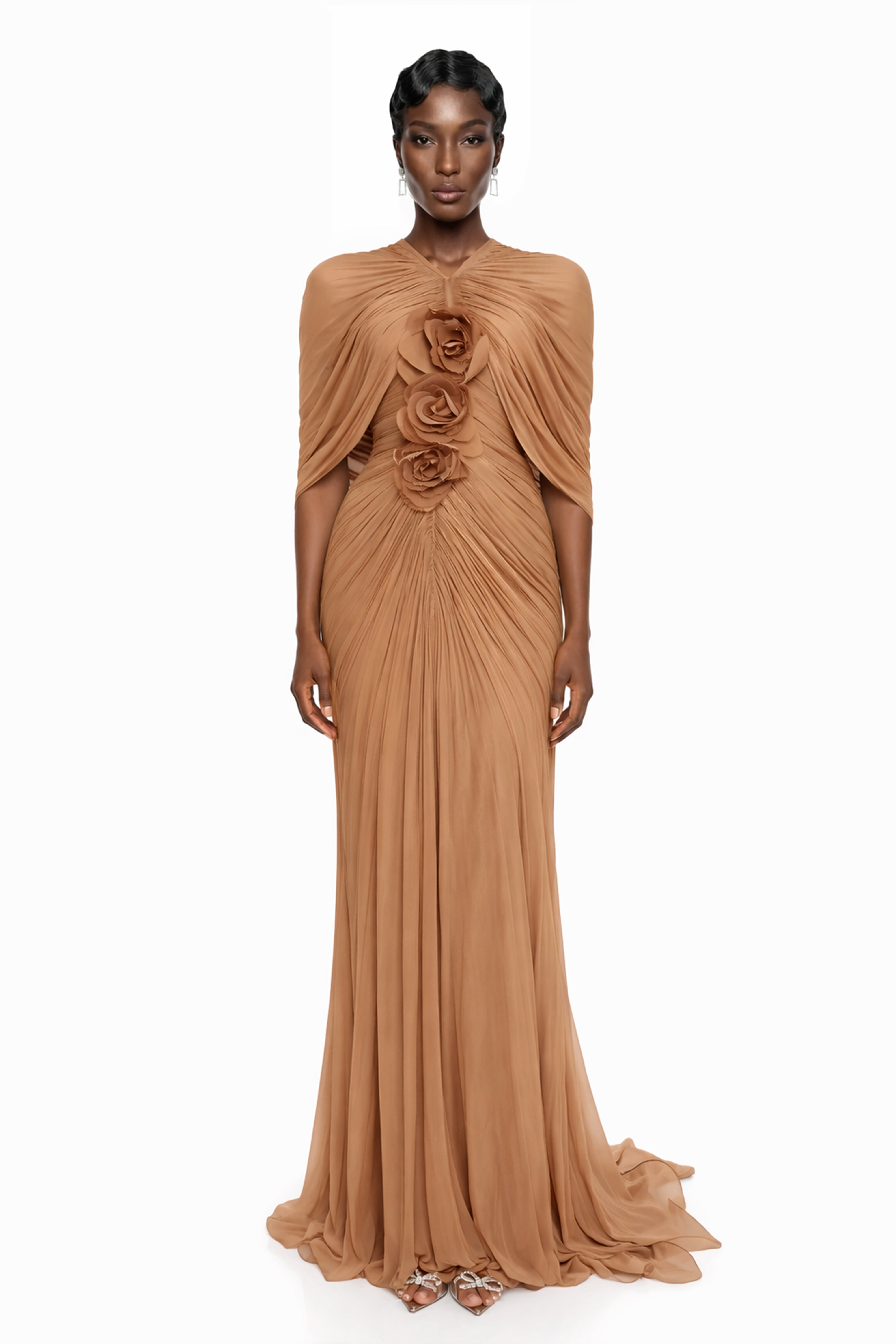 Tan ruched maxi dress featuring a built-in cape overlay and a vertical row of 3D fabric rosettes