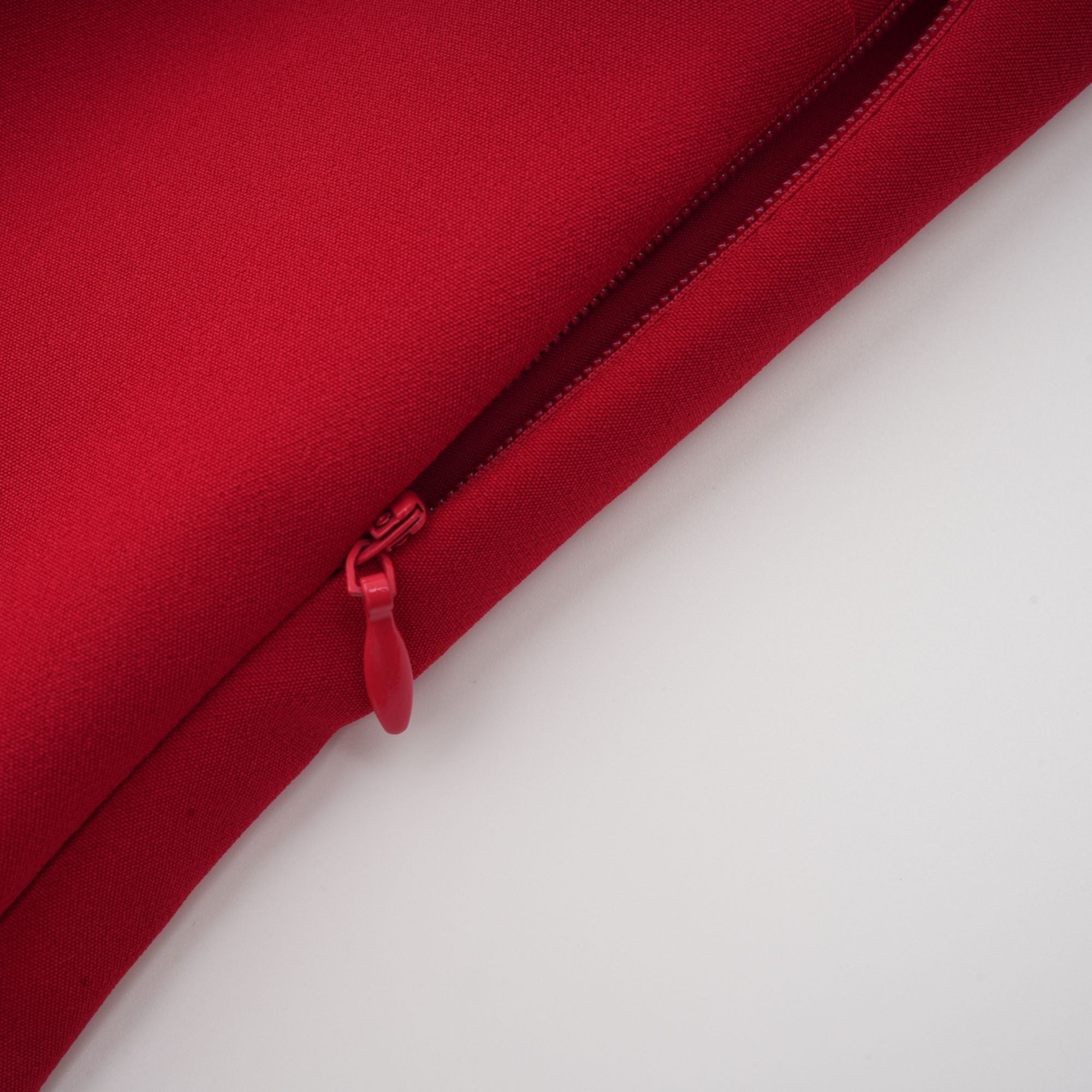 Robe rouge à manches longues et épaules dénudées, avec un panneau plissé sur la jupe