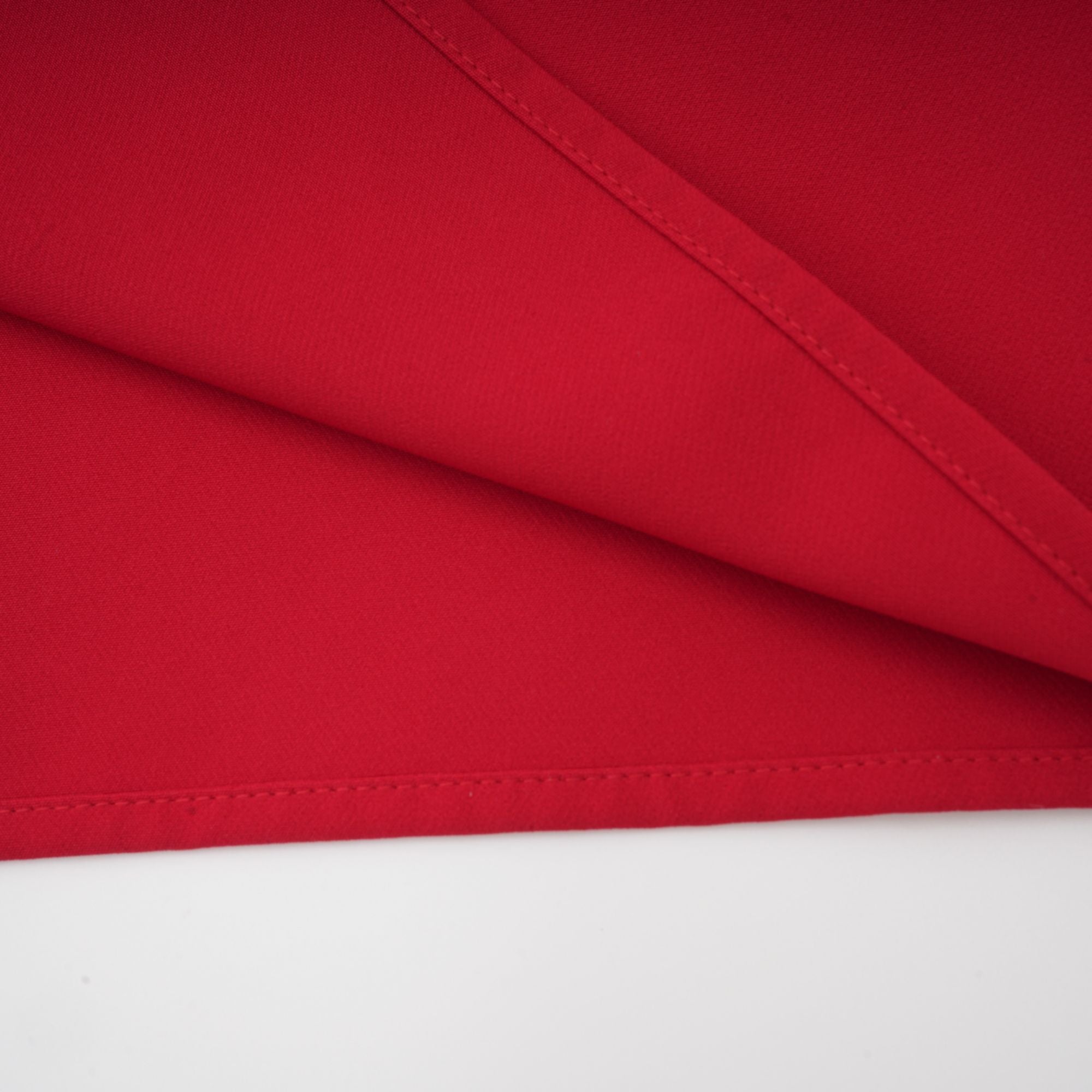 Robe rouge à manches longues et épaules dénudées, avec un panneau plissé sur la jupe