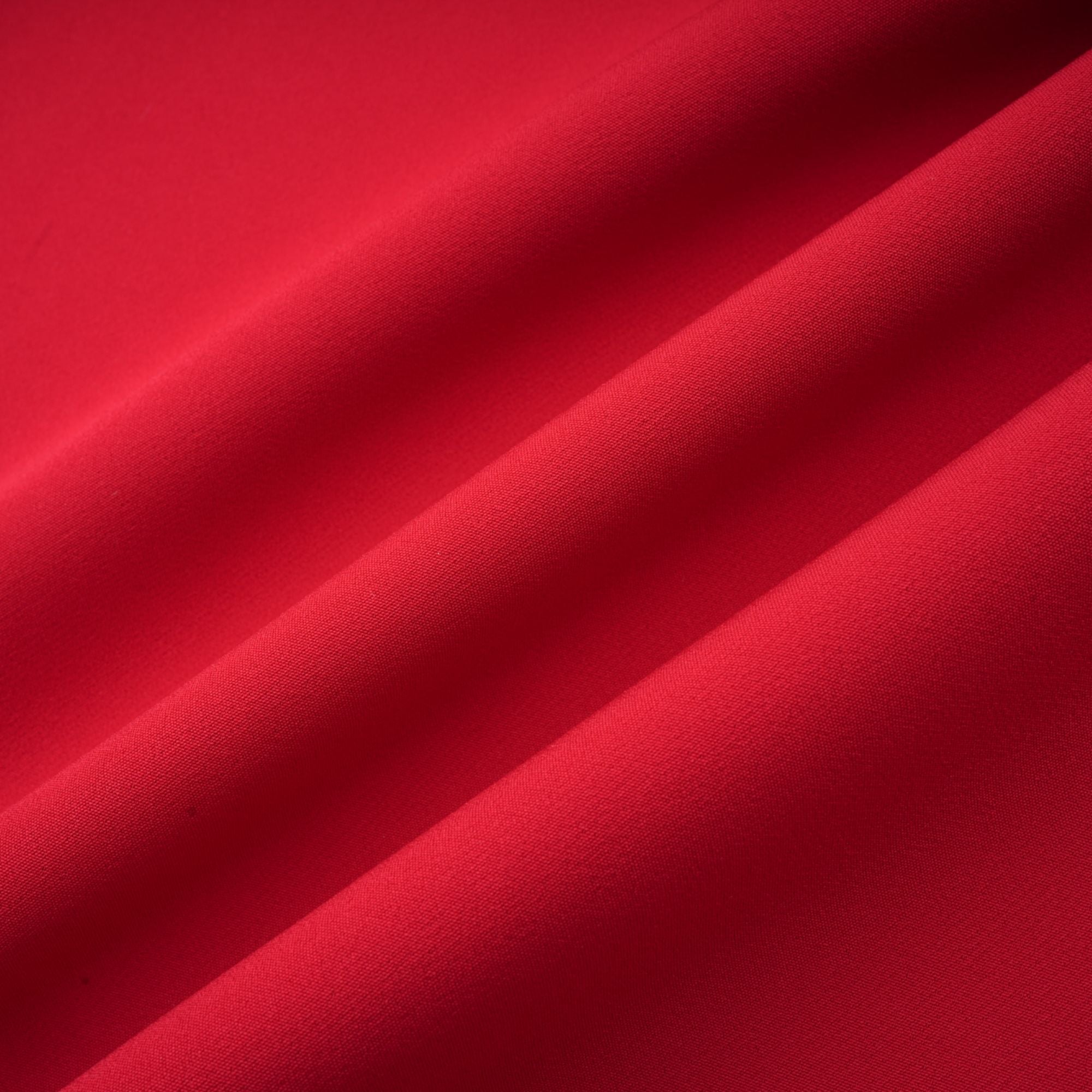 Robe rouge à manches longues et épaules dénudées, avec un panneau plissé sur la jupe