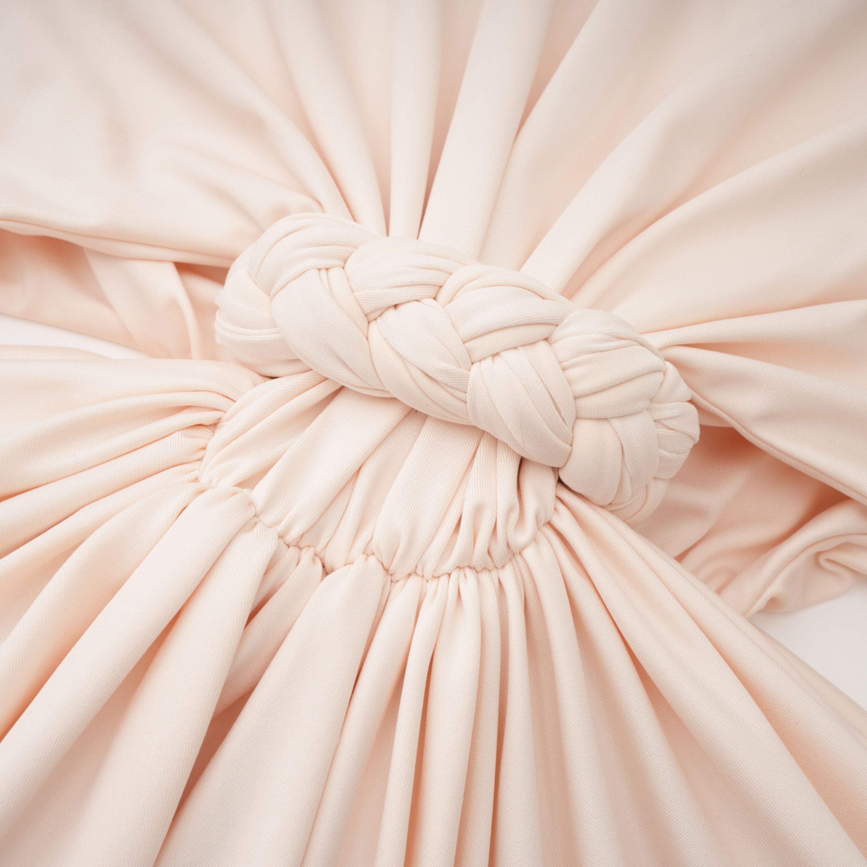 Cream halter maxi dress with waist cutouts and a knotted draped bodice
