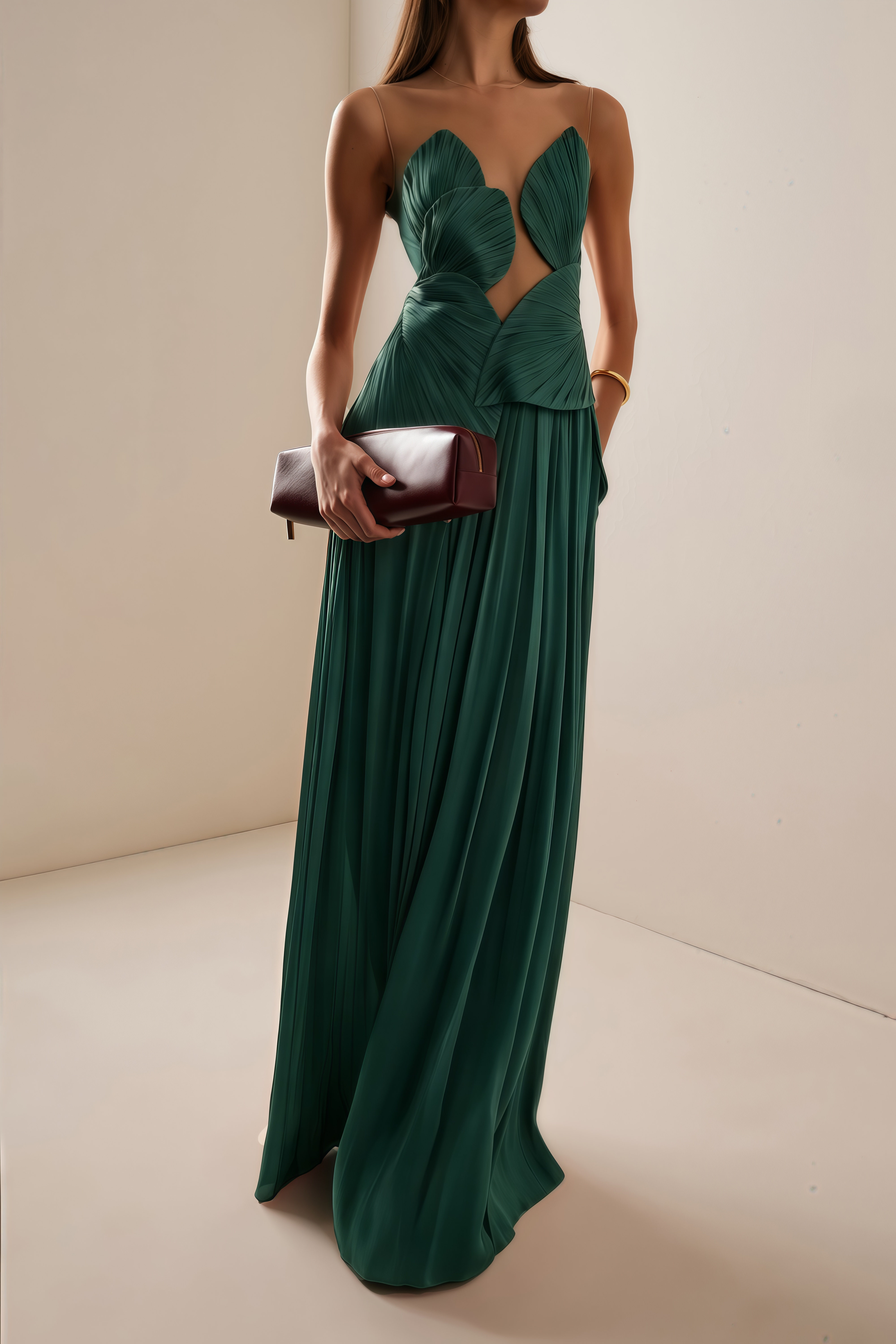 Emerald green pleated maxi dress featuring a structured geometric bodice with a sheer mesh illusion neckline