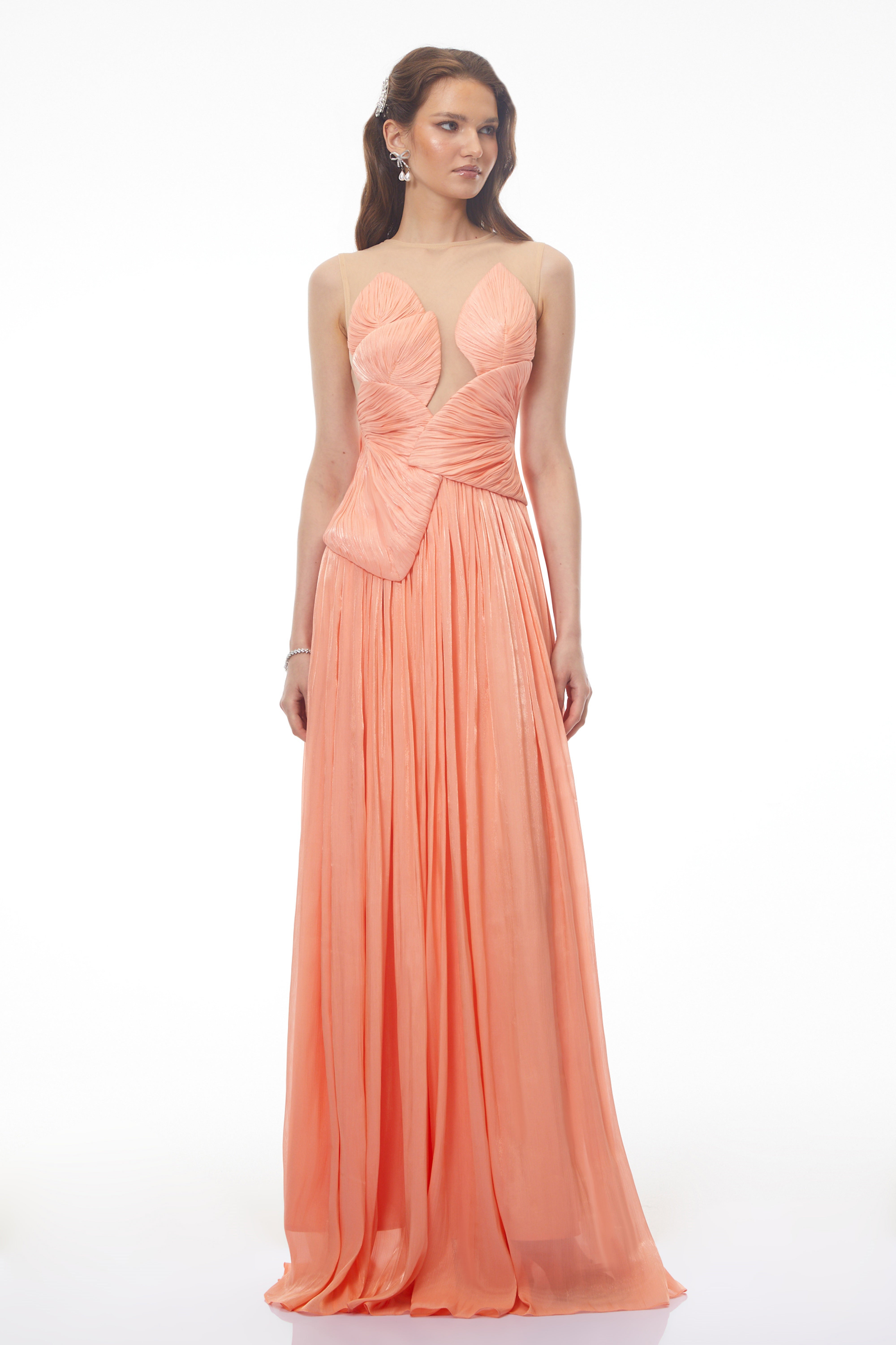 Peach pleated gown with a structured bodice and sheer illusion neckline