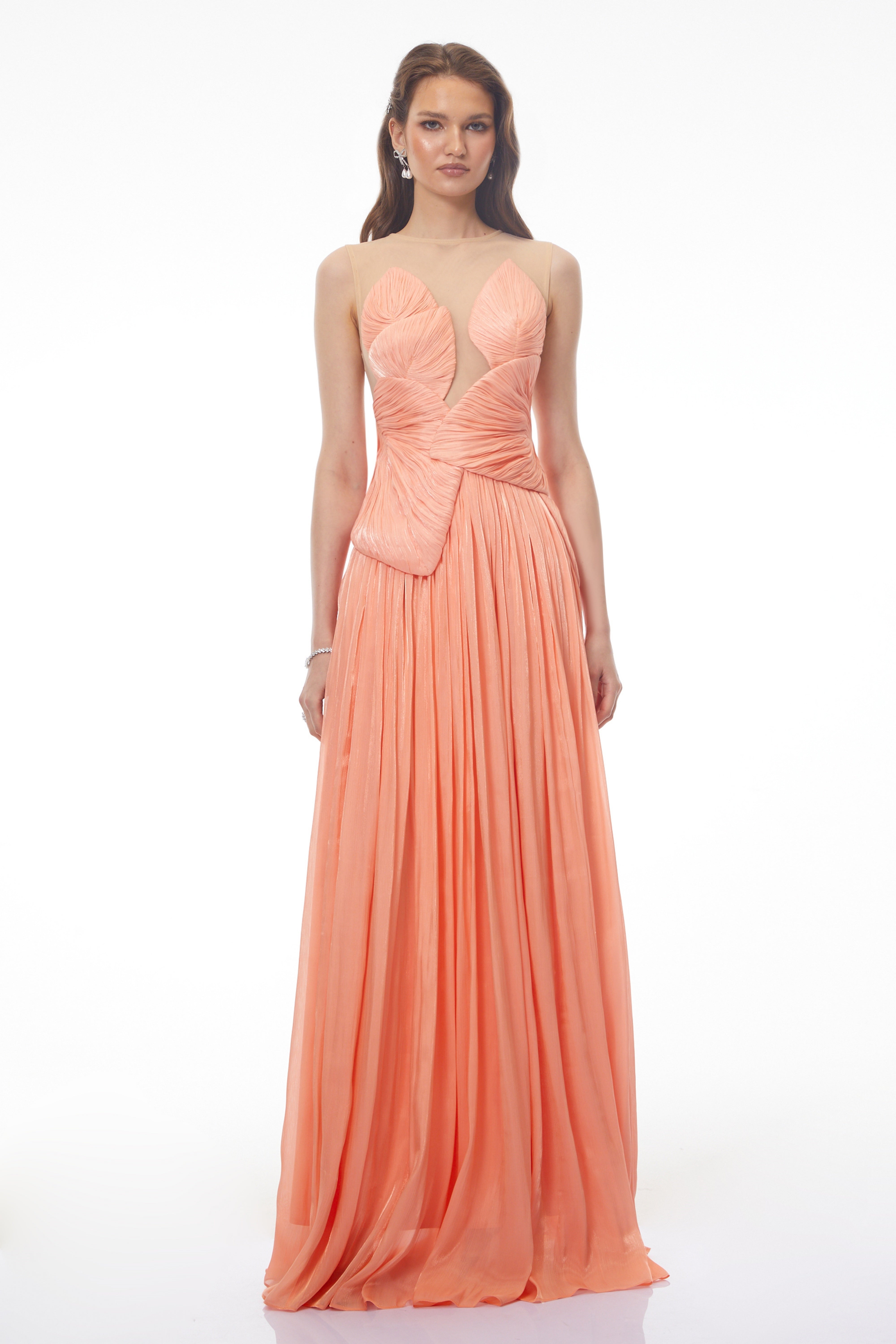 Peach pleated gown with a structured bodice and sheer illusion neckline