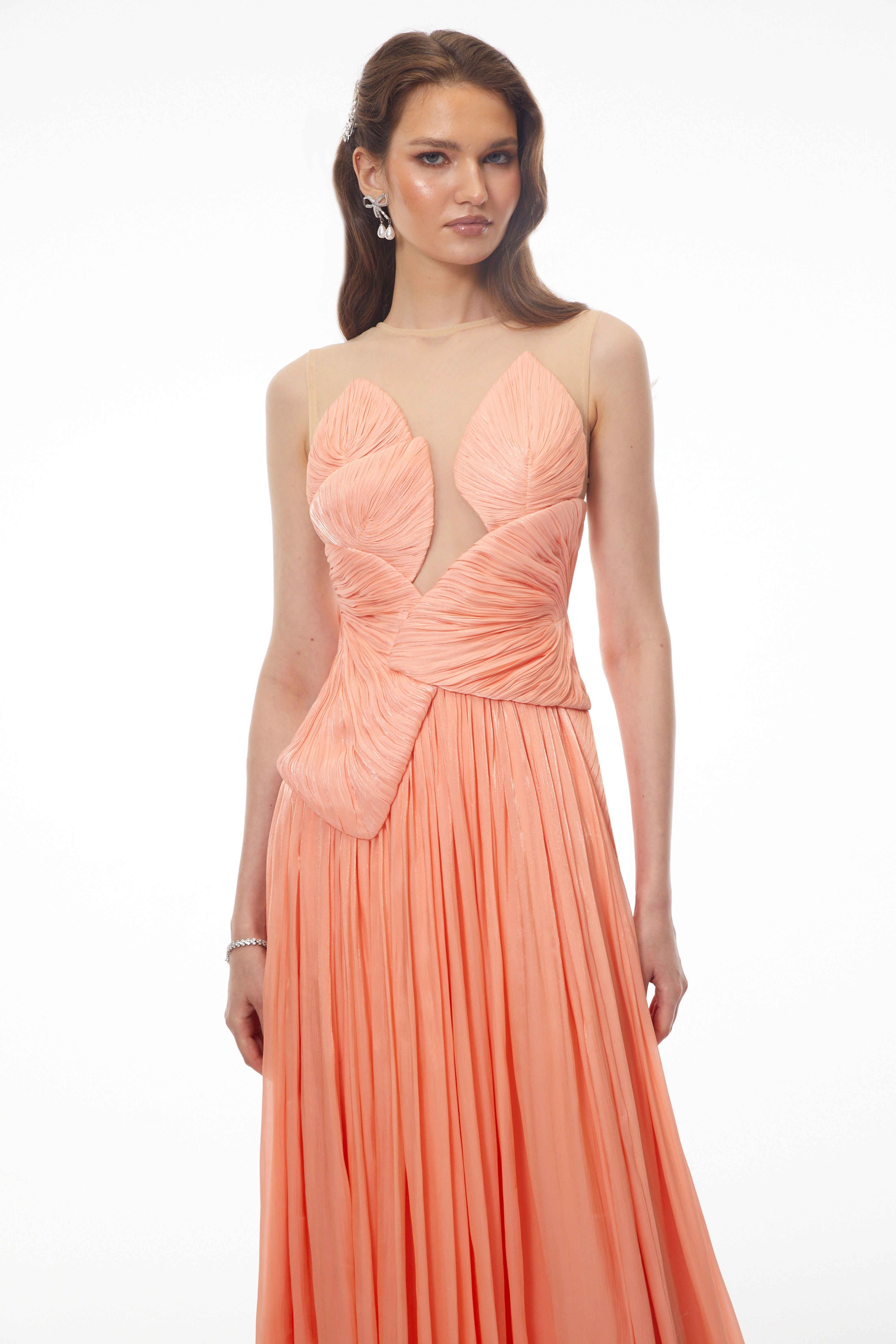 Peach pleated gown with a structured bodice and sheer illusion neckline