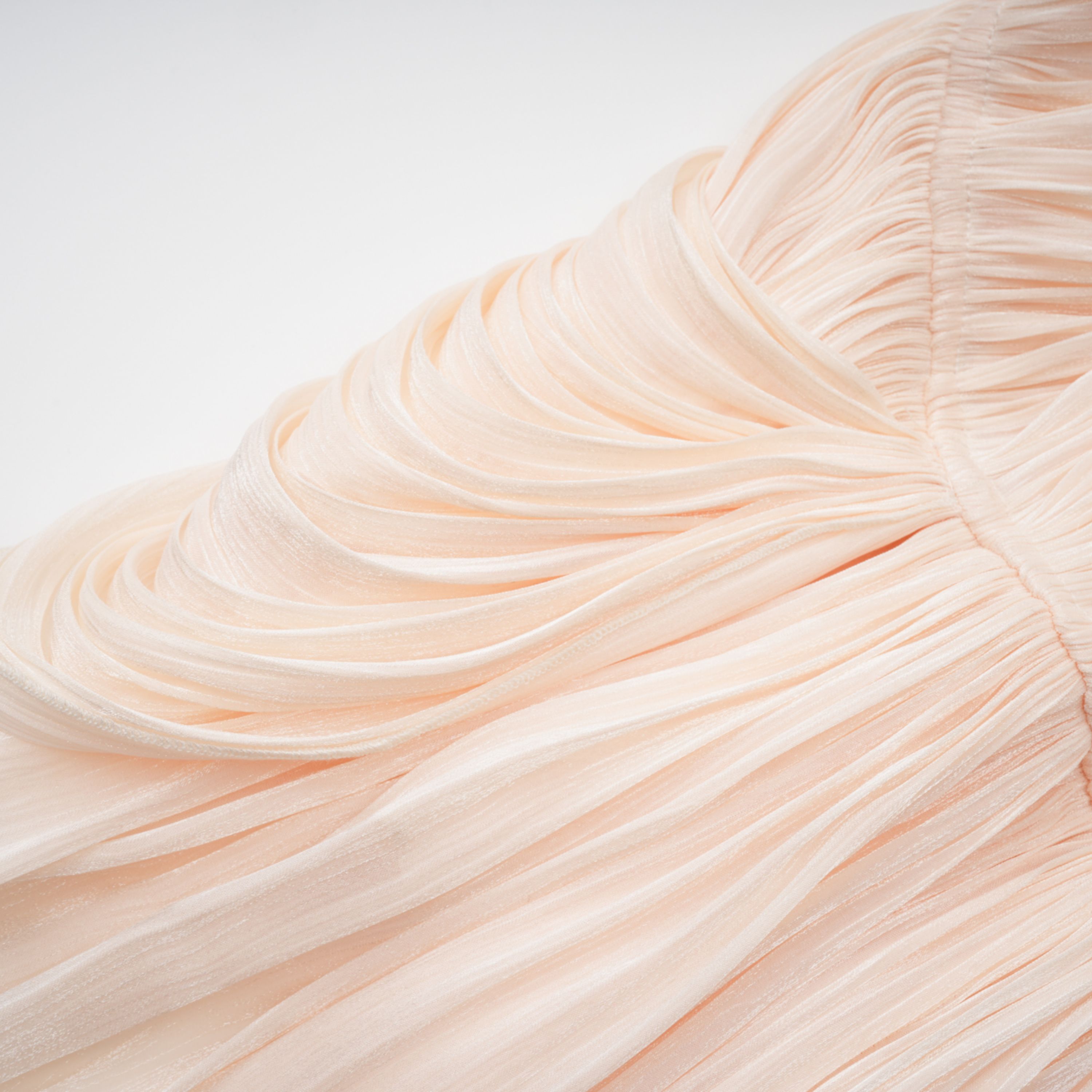 Cream plissé mini dress with a square neckline, structured puff sleeves, and a draped ruffled skirt