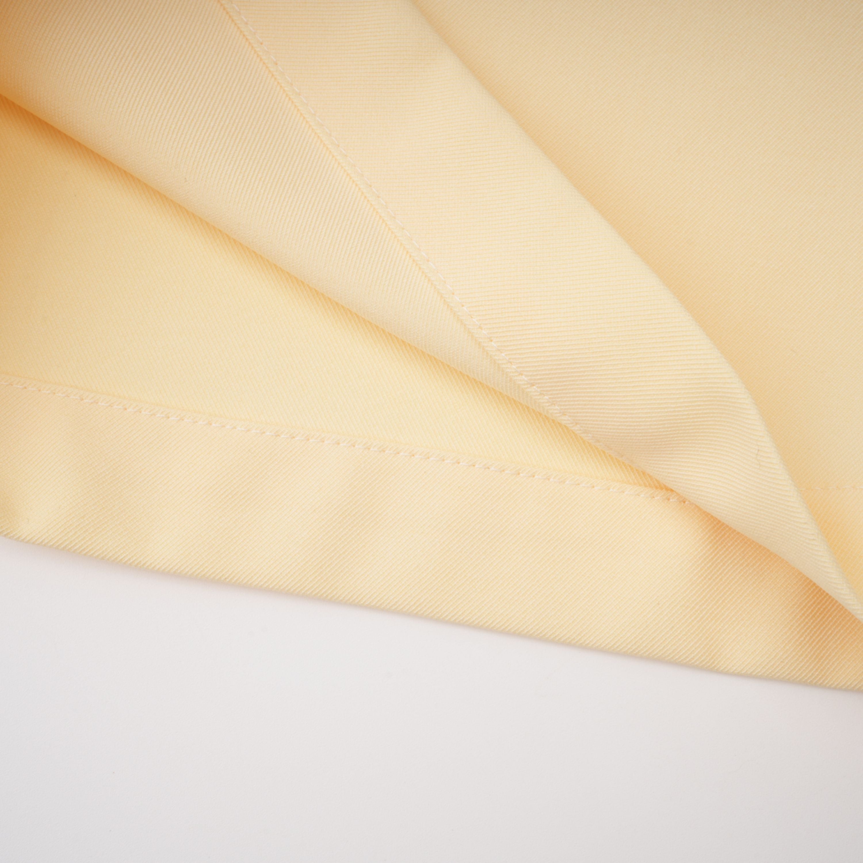 Pale yellow top and trousers set with an asymmetric blazer bodice, draped sheer neckline, and cape panels