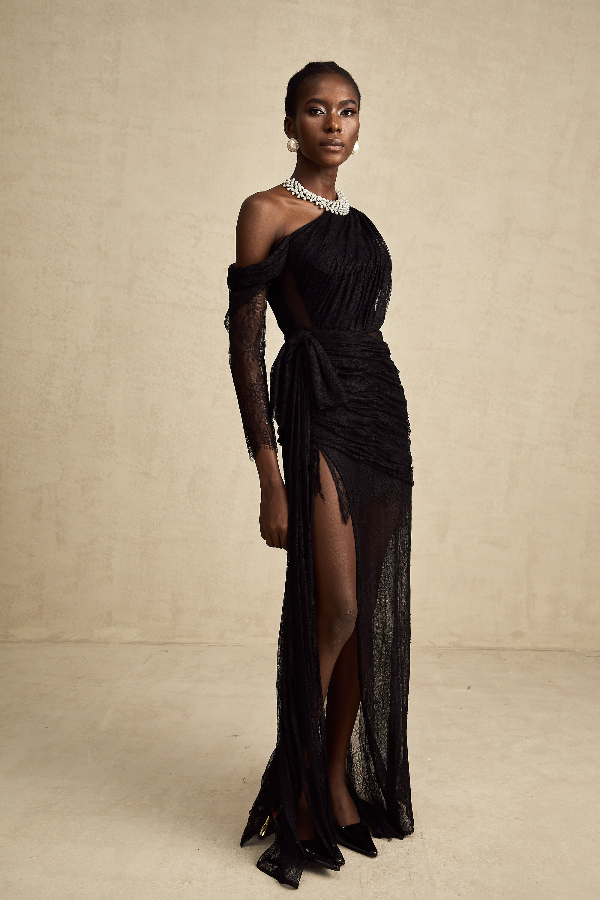 Robe longue noire asymétrique en dentelle, avec fronces et fente haute sur la jambe