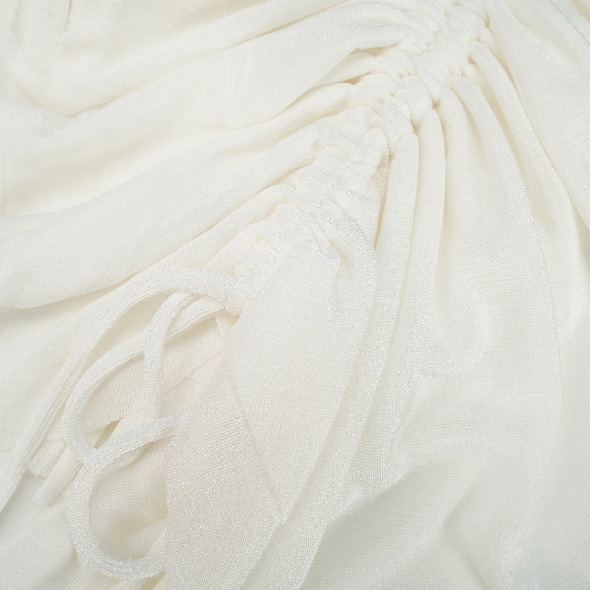 Mini-robe caraco blanche, avec un corsage structuré couleur beige et une jupe drapée à volants, agrémentée de cordons de serrage