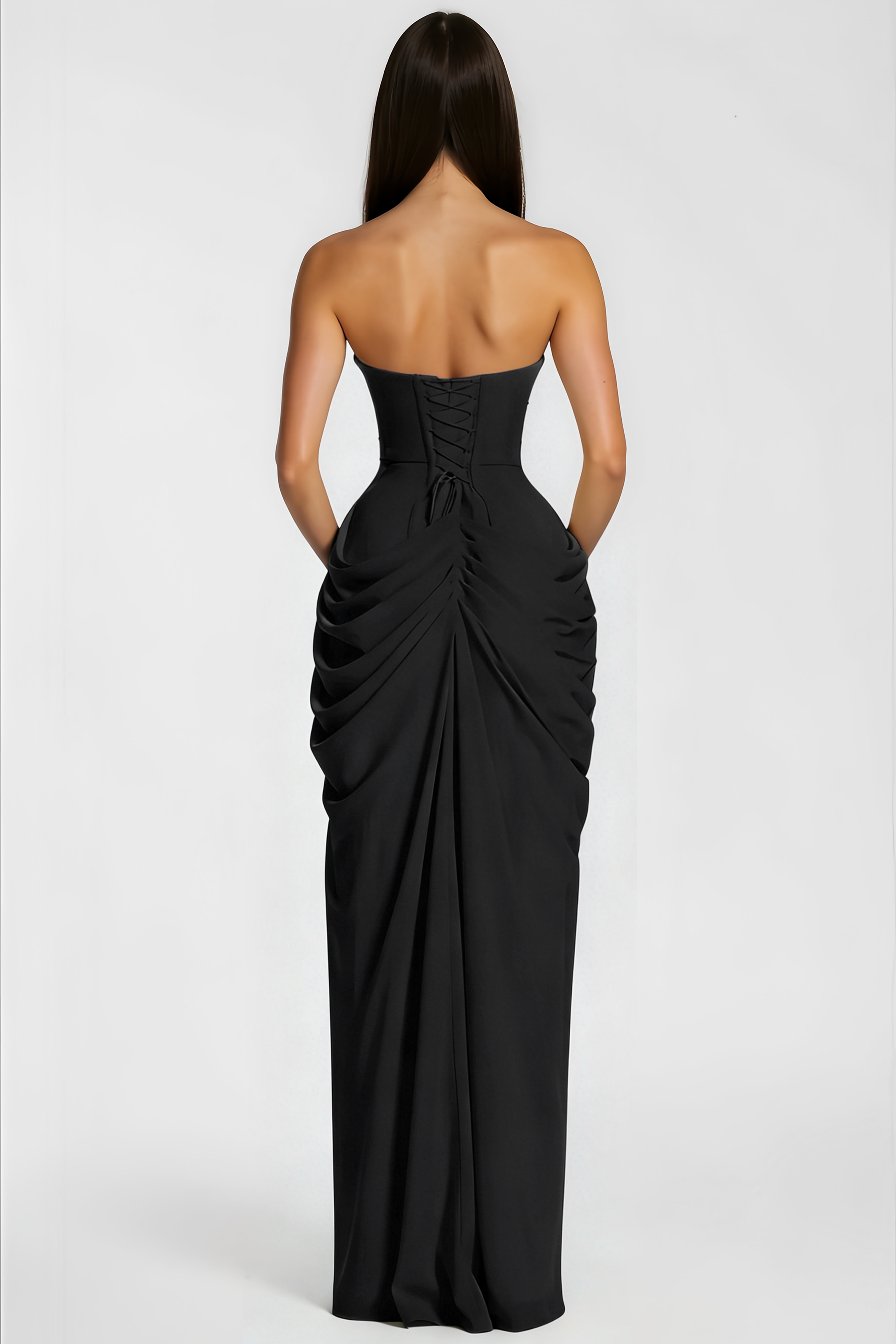 Black strapless maxi dress with a structured corset bodice, draped asymmetric skirt, and high leg slit