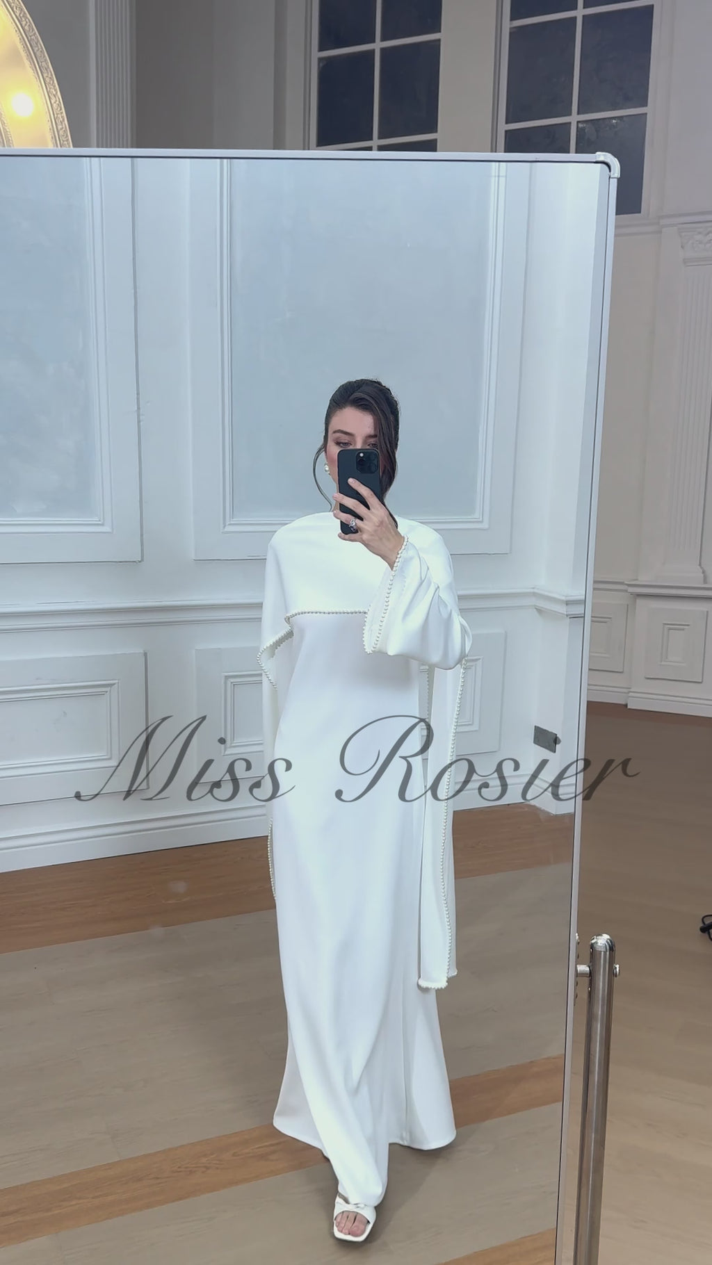 فستان أبيض بأكمام طويلة وياقة عالية وحواف مزينة باللؤلؤ